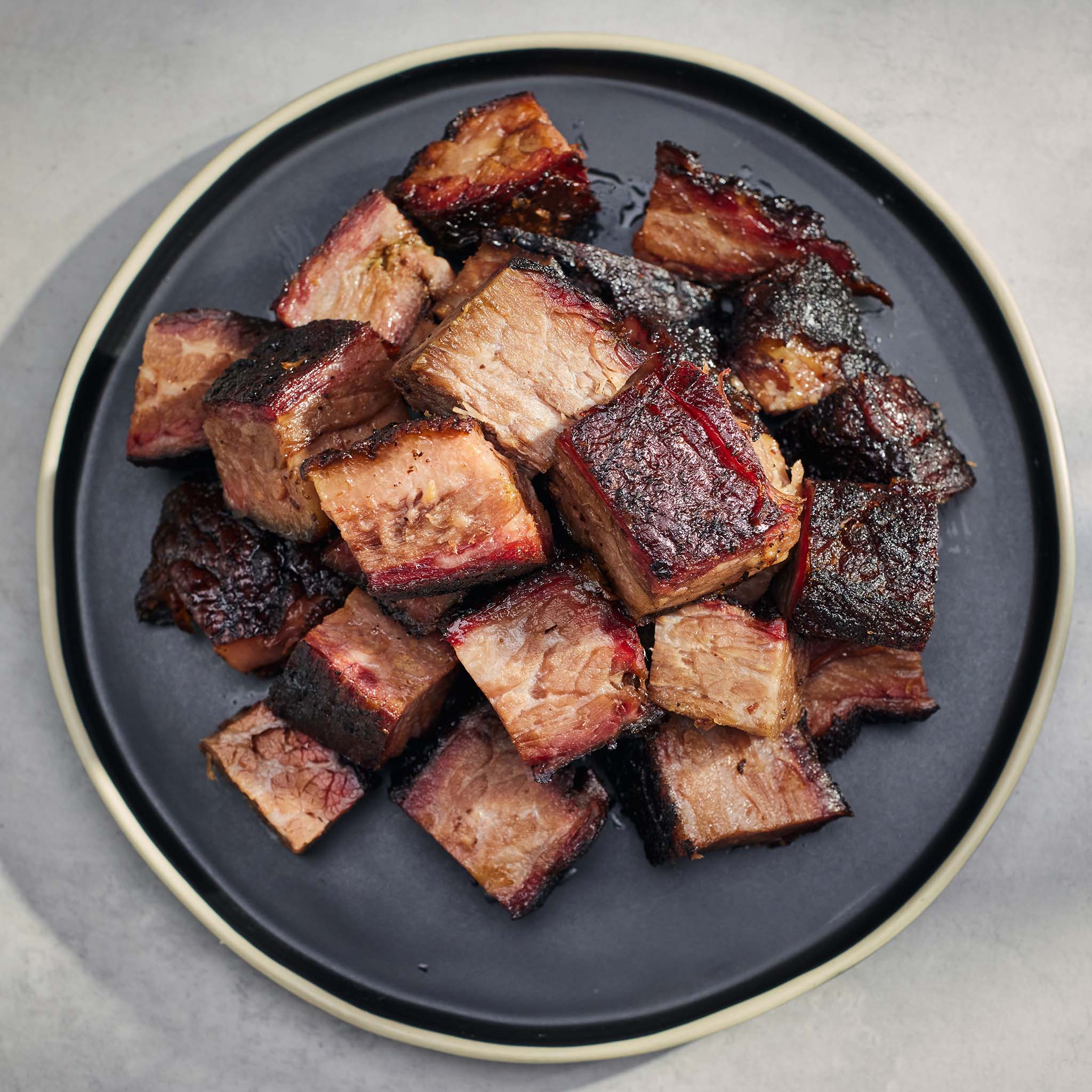 Plated barbecue-style meat chunks on a gray background
