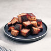 Beef burnt ends on a dark plate with a light background