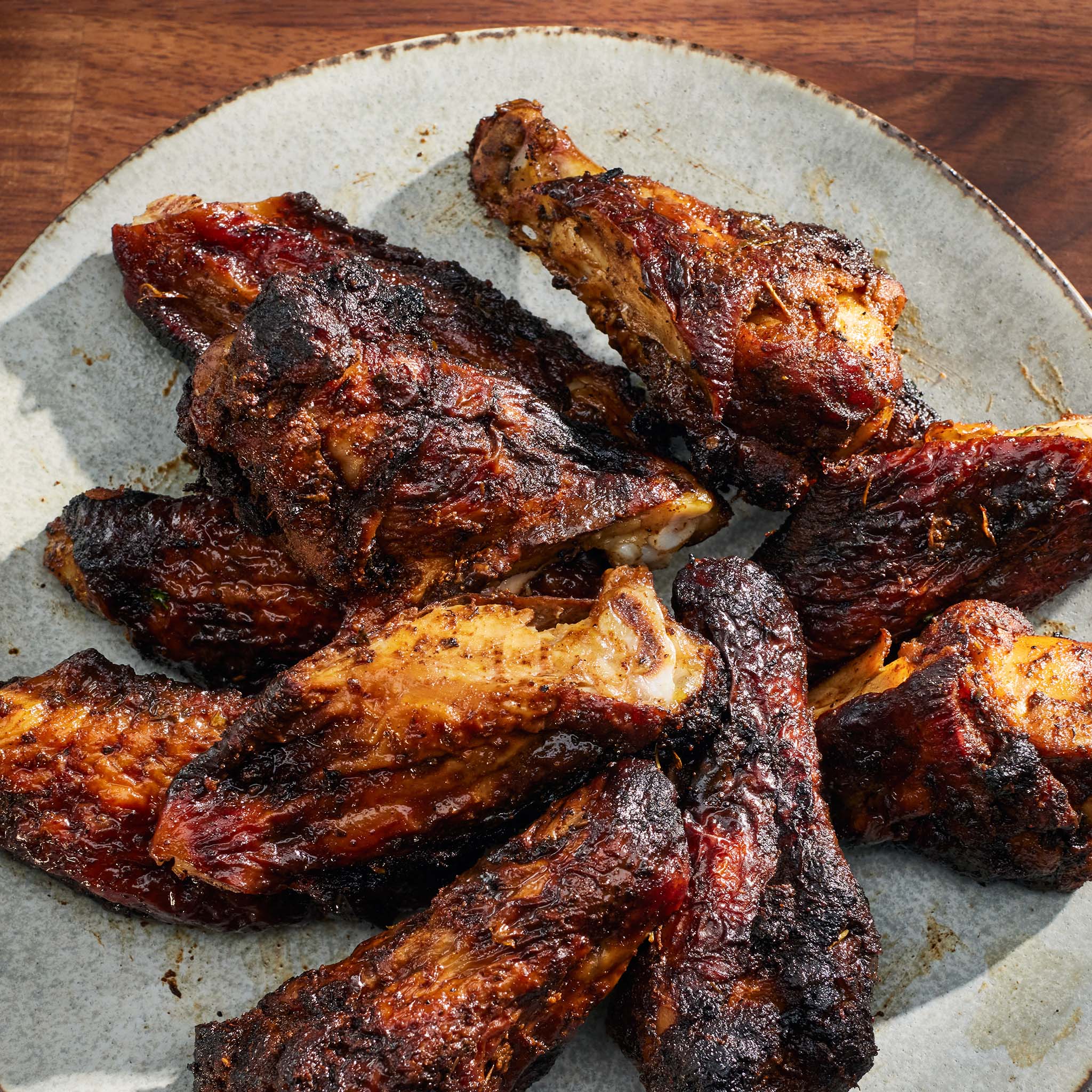 Baked chicken wings on a rustic stone plate with a wooden background