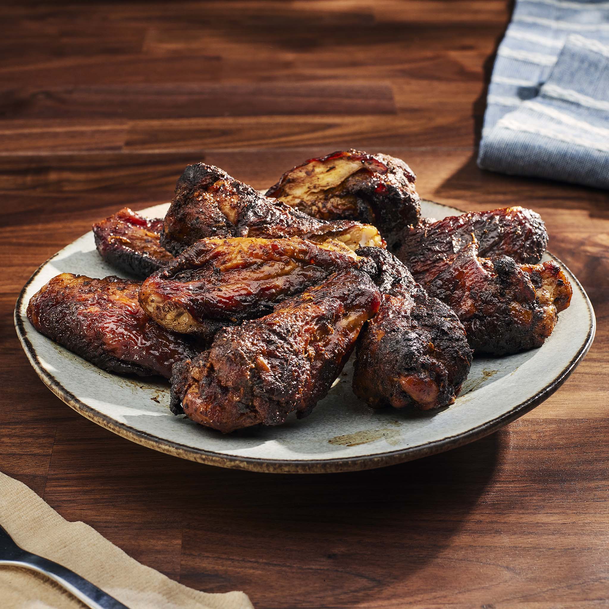 Grilled chicken wings on a plate with a wooden background