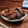 Grilled chicken wings on a plate with a wooden background
