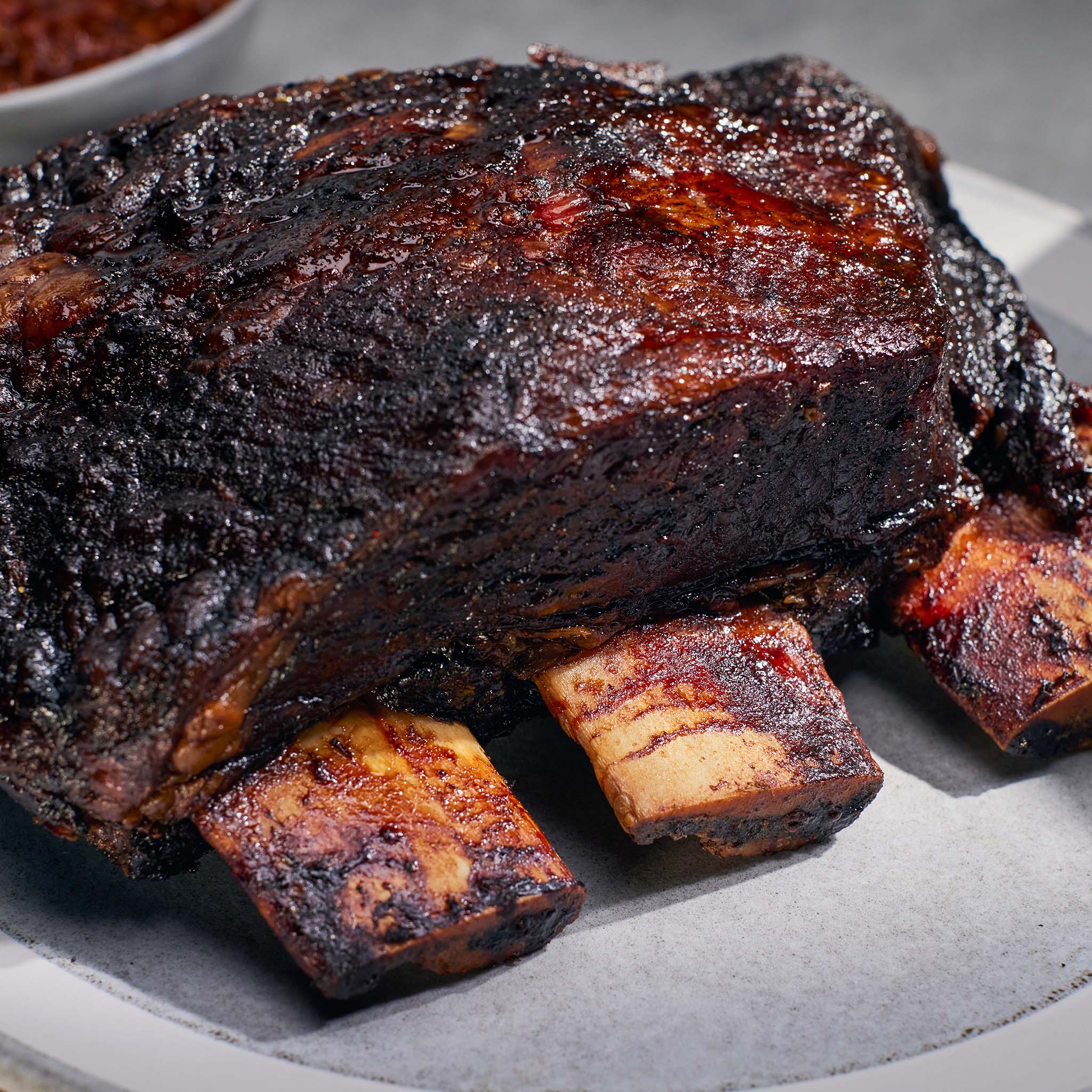 Close-up of smoked ribs on a plate with a blurred background