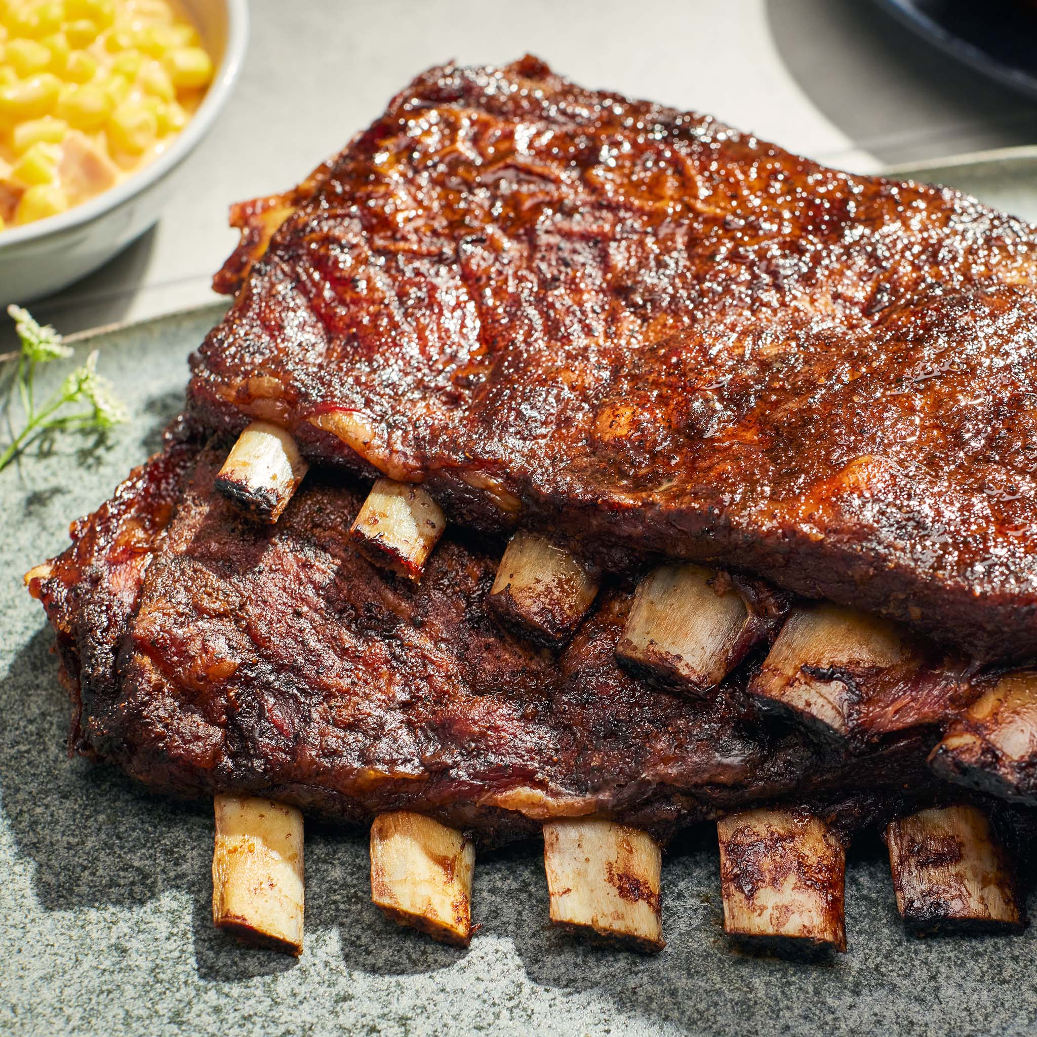 Barbecue ribs on a plate with a side of macaroni and cheese.