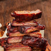 Stack of ribs on a wooden cutting board with a blurred wooden background