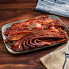 Sliced brisket on a platter with a wooden background