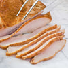 Sliced turkey with a knife and fork on a marble surface