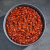 Bowl of baked beans on a dark surface