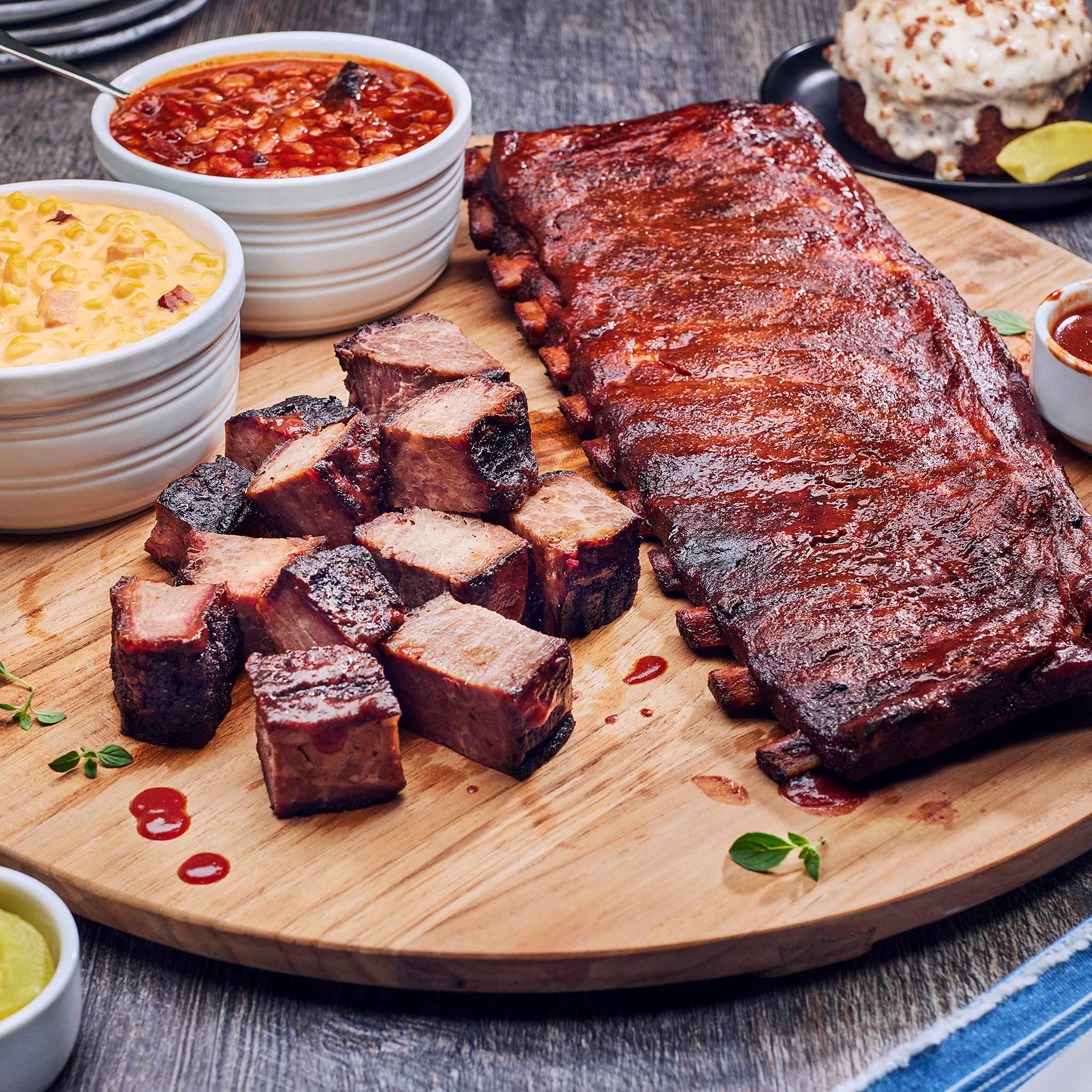 Plated barbecue ribs with sides on a wooden board