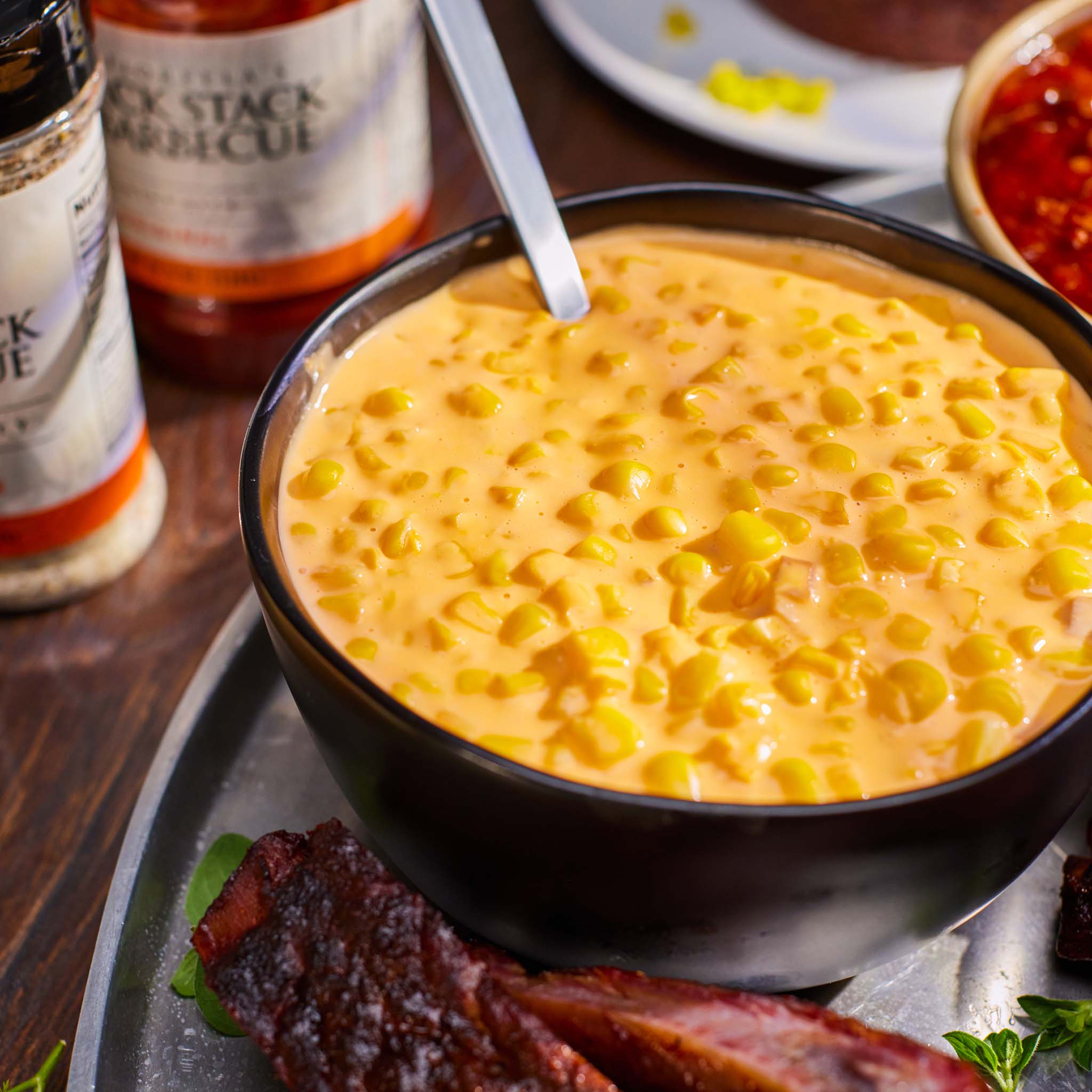 Bowl of corn and barbecue sauce in the background