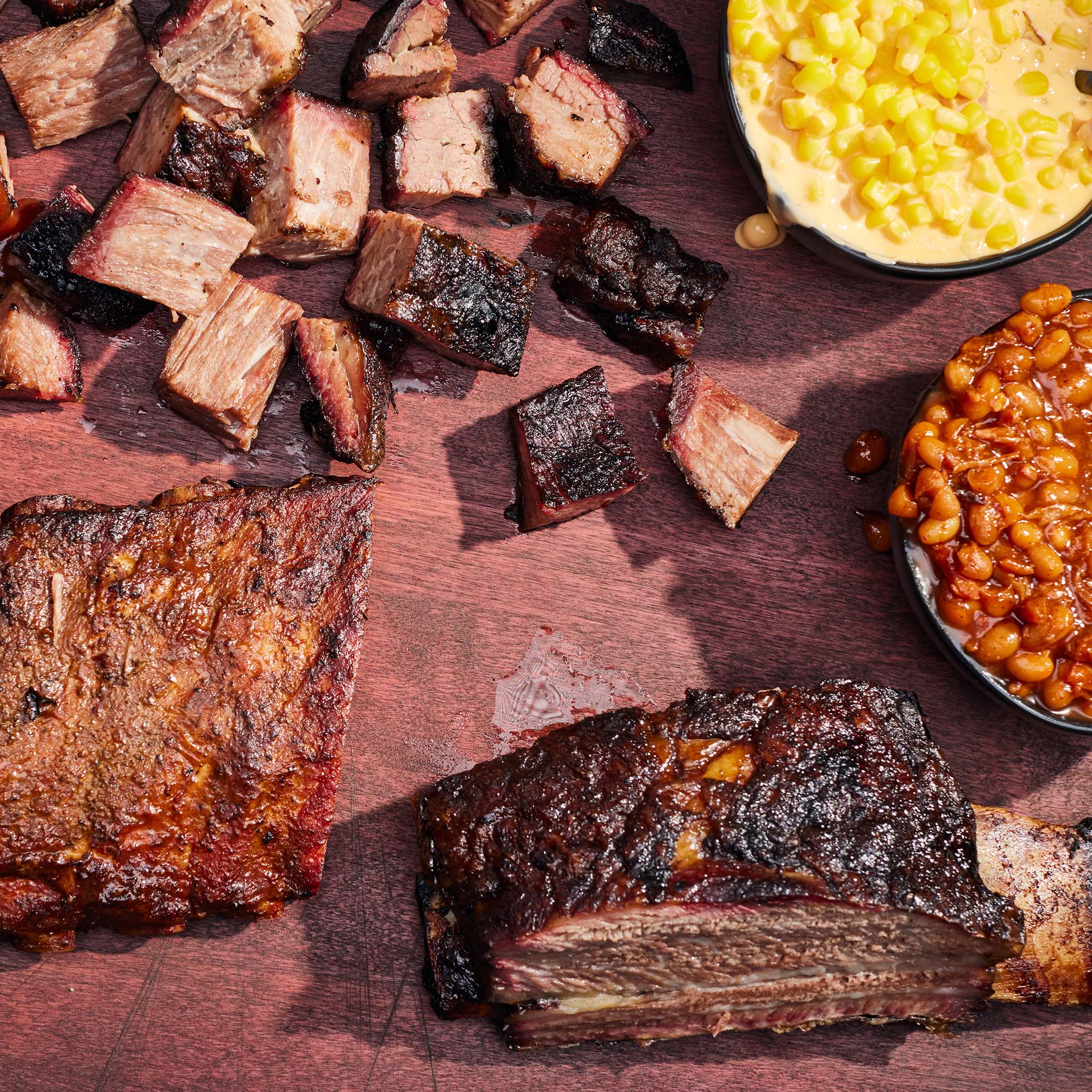 Barbecue meats and sides on a wooden surface