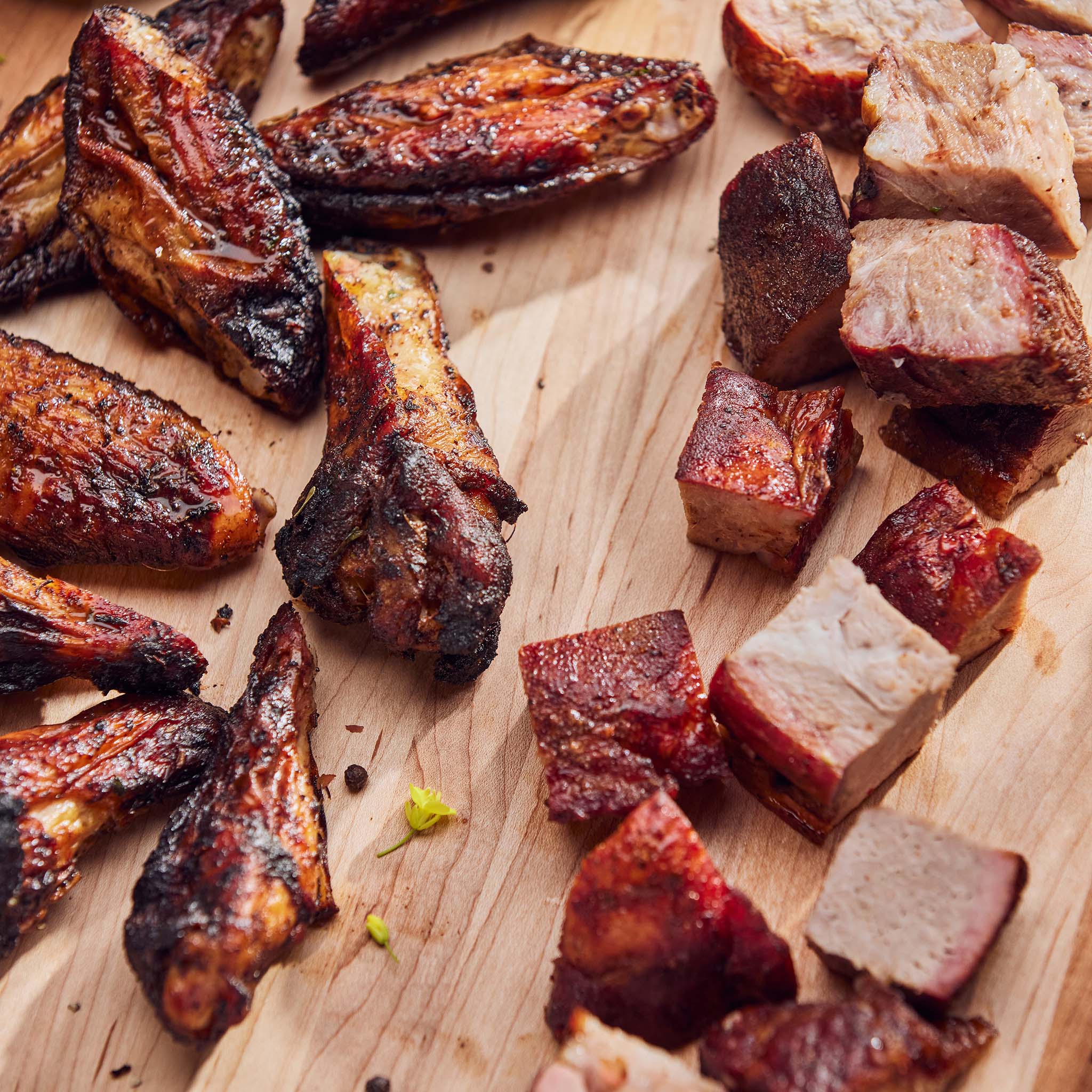 Grilled meat pieces on a wooden cutting board