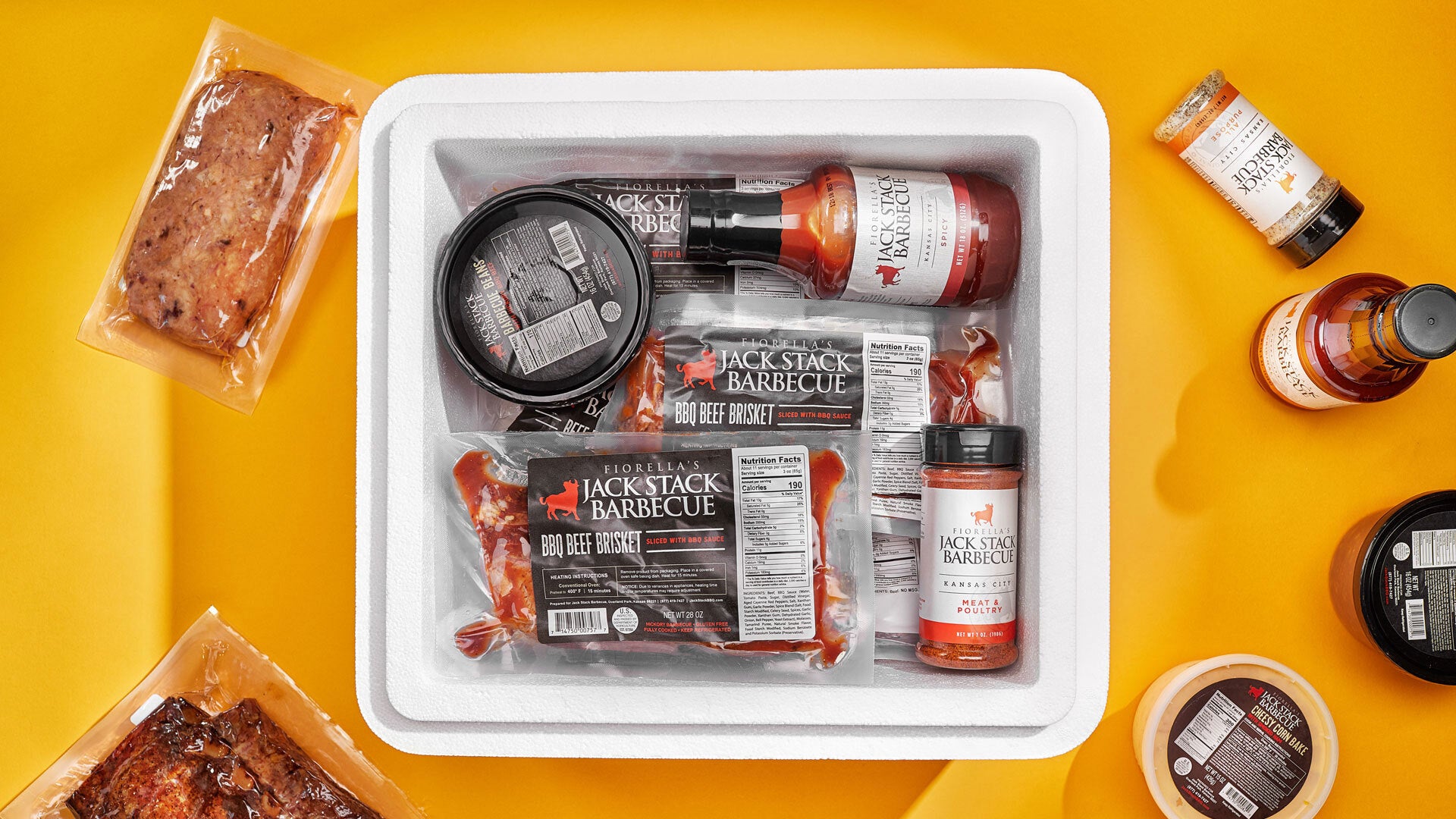 Assorted barbecue products including sausages, sauces, and seasonings on a yellow background.