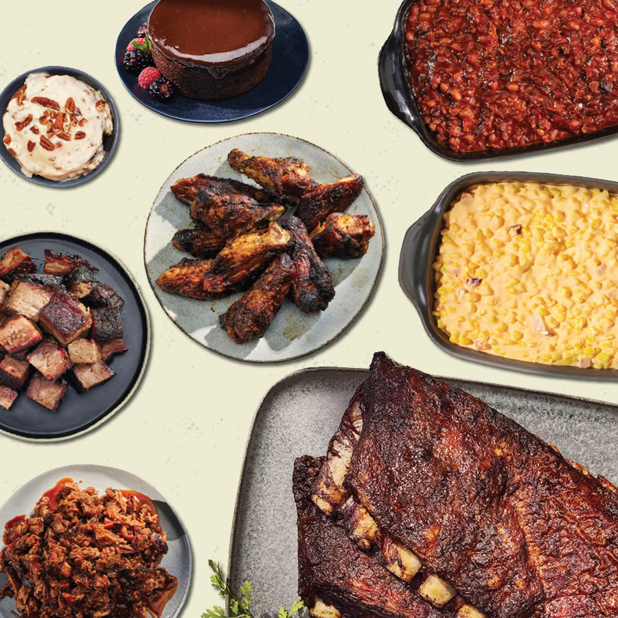 Assorted barbecue dishes including ribs, wings, corn, and sides on a light background