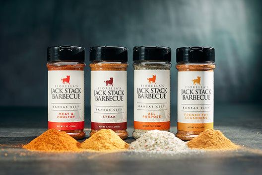 Four bottles of Jack Stack Barbecue seasonings with visible spices on a dark background